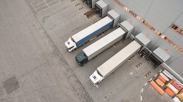 Luchtfoto van vrachtwagens lossen in logistiek centrum logo