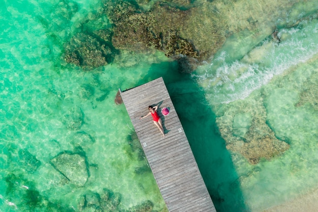 Luchtfoto van vrouw opleggen van houten pier op zonnige zomerdag in cancun mexico bovenaanzicht jonge sexy