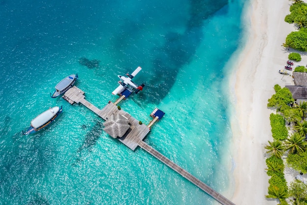 Luchtfoto van water bungalow pier en blauwe zee achtergrond in Maldiven. Watervliegtuig en houten boten