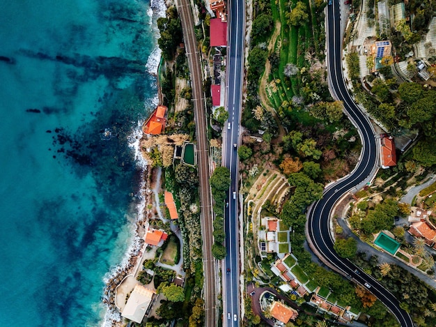 Luchtfoto van weg snelweg en spoorlijn langs oceaan of zee Drone fotografie van bovenaf op het platteland van Italië