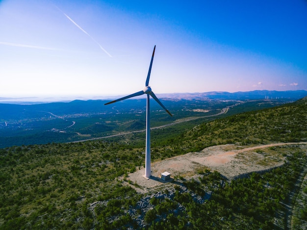 Luchtfoto van windmill energy farm bij zonsondergang windturbines voor elektrische energie met schone en hernieuwbare energie