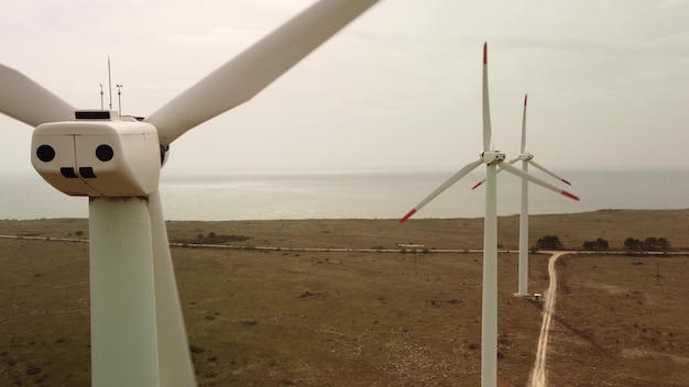 Luchtfoto van windturbines en landbouwveld in de buurt van de zee bij zonsondergang