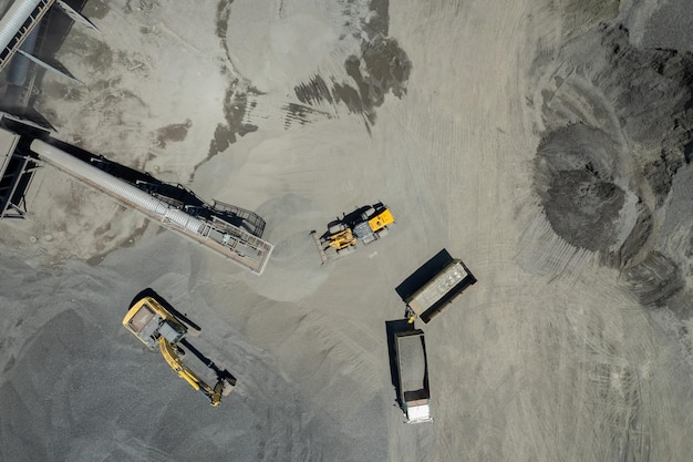 Luchtfoto van zandladers scheppen stenen in dumptrucks