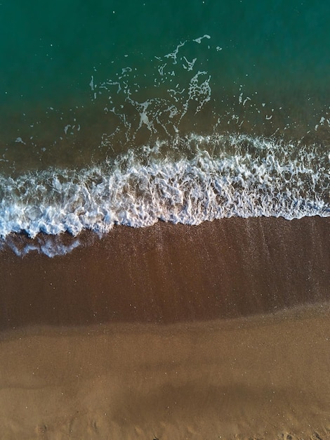 Luchtfoto van zandstrand en zee met golven Bovenaanzicht