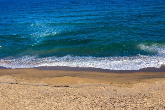Luchtfoto van zee golven en een afgelegen afgelegen zandstrand met een drone