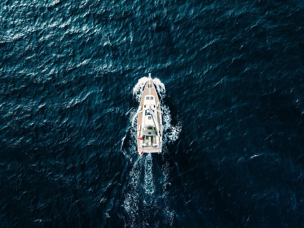 Luchtfoto van zeilschipjachten met witte zeilen in winderige staat in diepblauwe zee