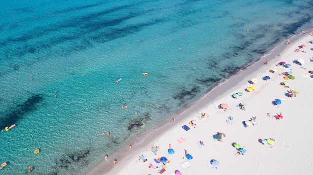 Luchtfoto van zomer strand vol toeristen genieten van zee oceaan vakantie Concept van reizen en geweldige bestemming Wit zand en blauw oceaanwater met groepen mensen zonnebaden gelukkig Drone uitzicht