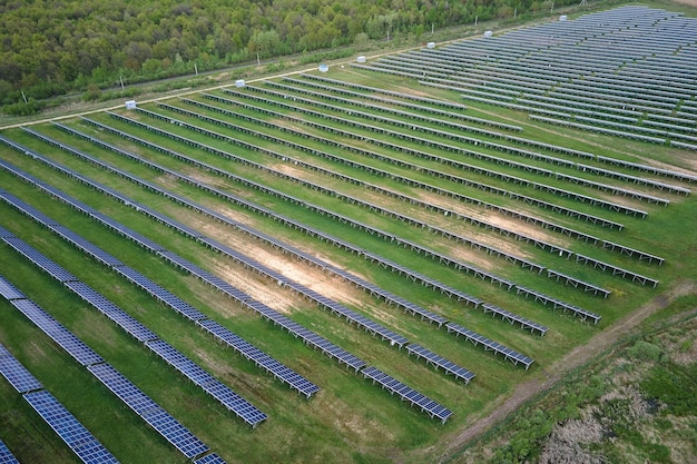 Luchtfoto van zonne-energiecentrale op groen veld Elektrische boerderij met panelen voor het produceren van schone ecologische energie