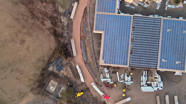 Luchtfoto van zonnepanelen geïnstalleerd op het gebied van industriële magazijnen op het dak