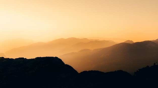 Luchtfoto van zwarte bergsilhouetten geïsoleerd op een oranje achtergrond