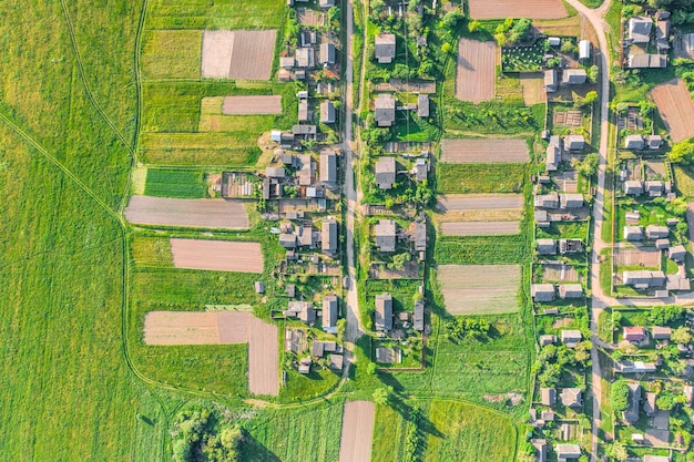 Foto luchtfoto vanaf de hoogte van het dorp met huizen en straten omgeploegde velden weiden in de zomer