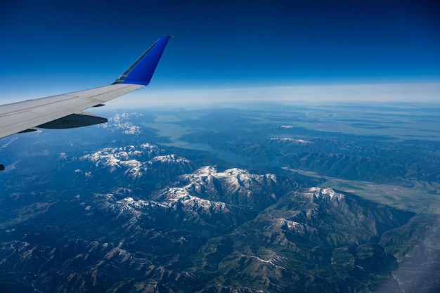 Luchtfoto vanuit een vliegtuig dat over prachtige bergen vliegt bedekt met sneeuw