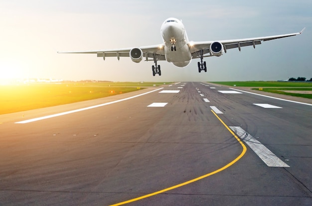 Luchthaven landingsbaan vliegtuigen met sporen van rubberen banden bij zonsopgang in de ochtend met schittering van de zon.