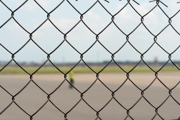 Luchthavenmedewerkers zijn op de startbaan Het grondgebied van het privévliegveld is omheind met prikkeldraad en een hek De verkeersleider leidt het vliegtuig