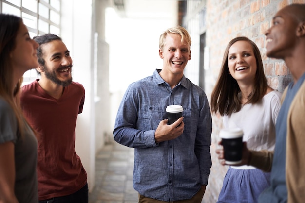 Luchtige discussie met klasgenoten Shot van een diverse groep universiteitsvrienden pratend in een gang