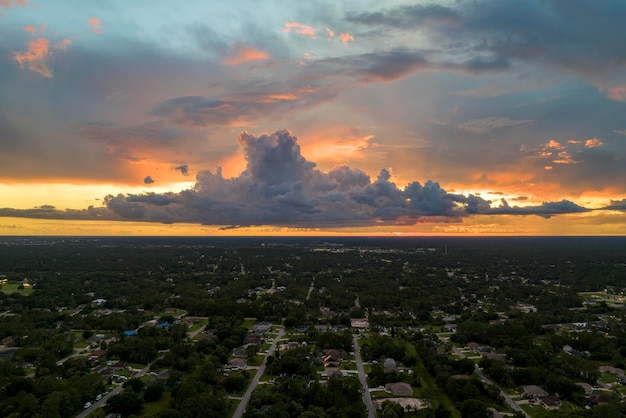 Luchtlandschapsmening van privéhuizen in de voorsteden tussen groene palmbomen in het rustige landelijke gebied van Florida bij zonsondergang