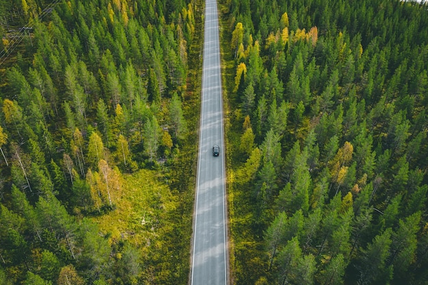 Luchtmening van auto op een landweg in groen bos in Finland