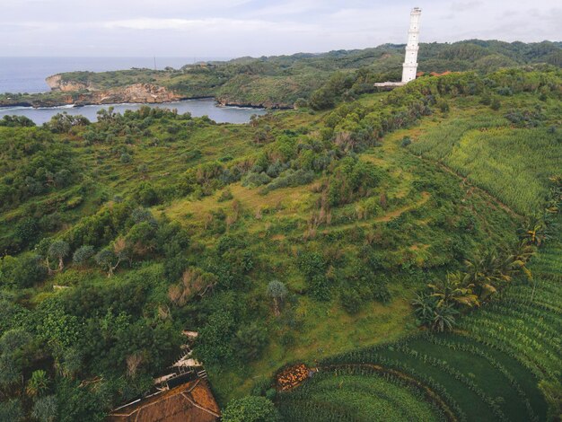 Luchtmening van Baron-strand in Yogyakarta Indonesië met vuurtoren en traditionele boten