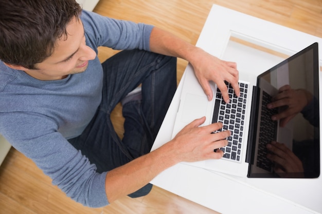 Luchtmening van een mens die laptop in woonkamer met behulp van