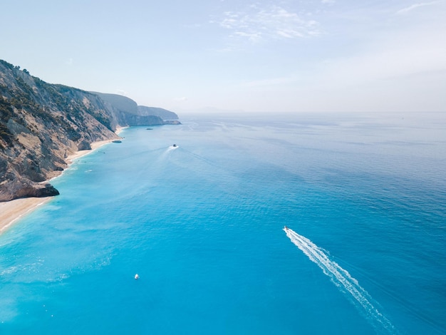 Luchtmening van Egremni-strand bij Lefkada-eilandsnelheidsboot bij blauw water