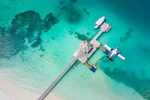 Luchtmening van het watervliegtuig van de pijlerboot in het eiland van de Maldiven. Exotisch schilderachtig landschap, zandige kust van de oceaanbaai