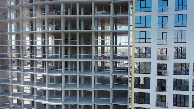 Luchtmening van hoog woonflatgebouw in aanbouw. Veel ramen op de gevel van een nieuw appartementengebouw in aanbouw. Vastgoed Ontwikkeling.