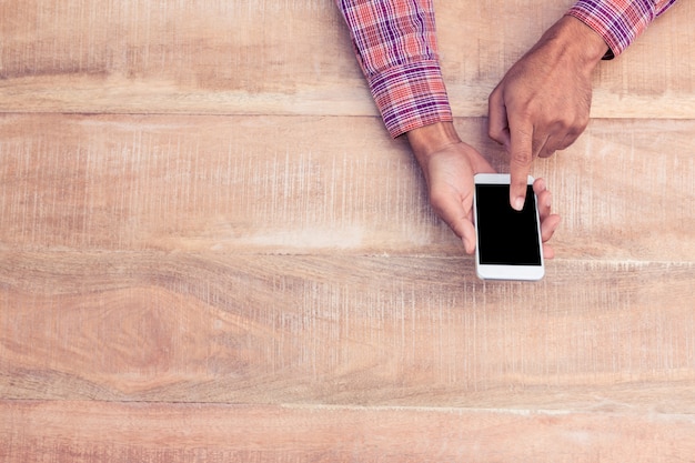 Luchtmening van mens het gebruiken van telefoon over lijst