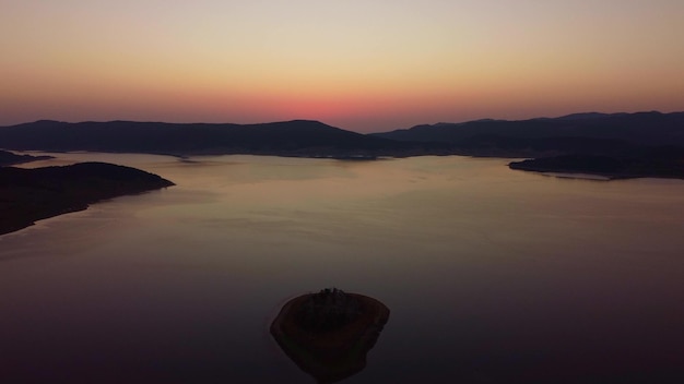 Luchtpanorama van eiland op een Batak-reservoir in zonsopgang Rhodopa-gebergte Bulgarije