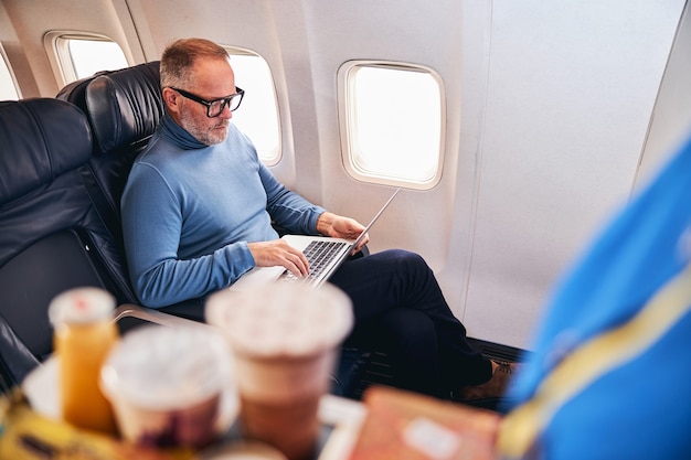Luchtreiziger die zijn computer in het vliegtuig gebruikt