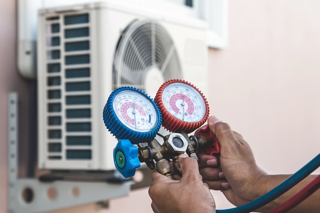 Luchtreparatiemonteur die manometerapparatuur gebruikt voor het vullen van de airconditioner in huis.