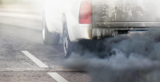 Luchtvervuilingscrisis in de stad door de uitlaatpijp van dieselvoertuigen op de weg