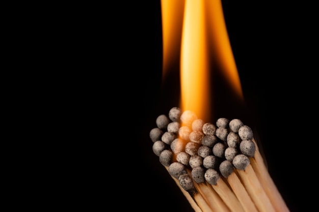 Lucifers op een zwarte achtergrond hebben de vorm van een hart en branden af met een feloranje vlam