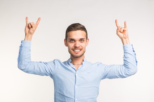 Luck and dancing concept - Cheerful young man dancing on white wall