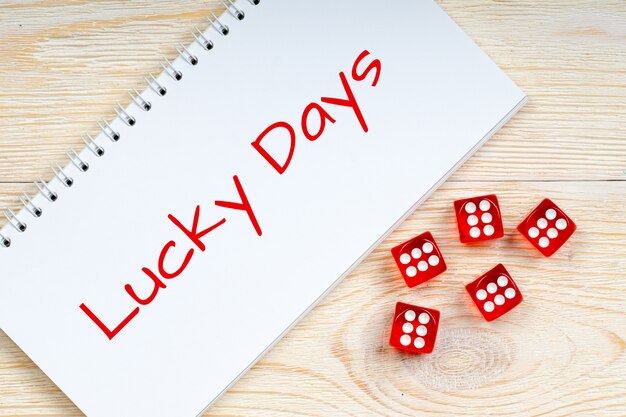 Lucky Days text with red dice on wooden table