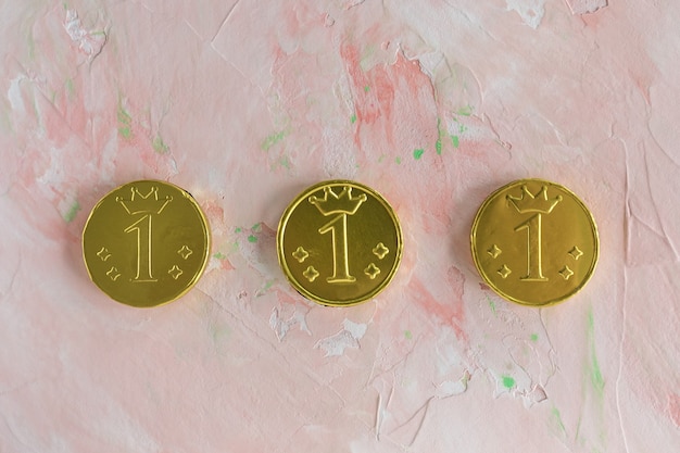 Фото Счастливые золотые шоколадные монеты на розовом фоне с копией пространства день святого патрика и концепция финансов