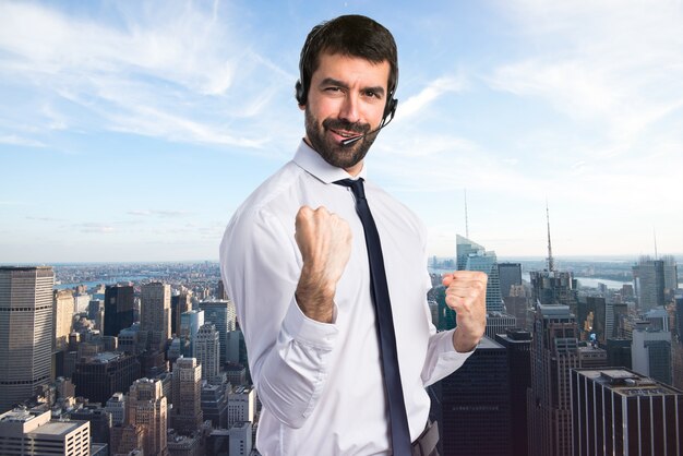 Lucky young man with a headset on unfocused background