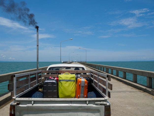 Luggage in truck on bridge over sea against sky