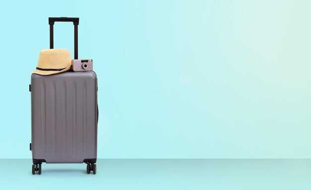 luggage with hat against blue background