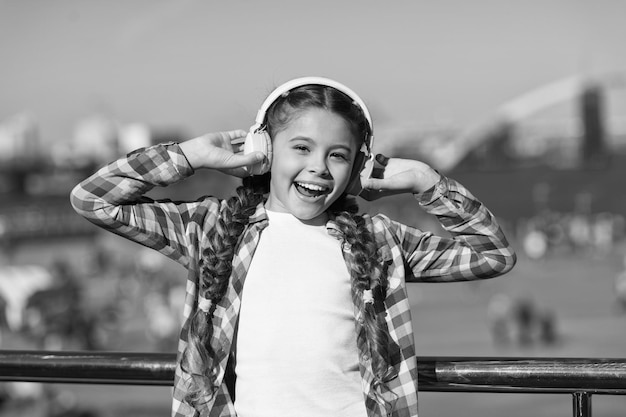 Luister gratis Muziek krijgen Gezinsabonnement Toegang tot miljoenen nummers Geniet overal van muziek De beste muziek-apps die het waard zijn om te luisteren Meisjeskind luistert buitenshuis naar muziek met moderne hoofdtelefoons