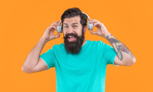 Luisteren naar muziek modern apparaat van blije kerel hipster kerel die muziek luistert in oortelefoons