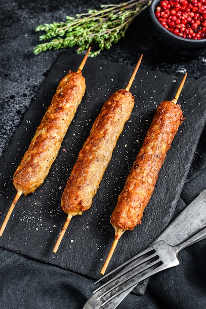 Lula kebab. Shish kebab on a stick, from ground beef meat. Black background. 