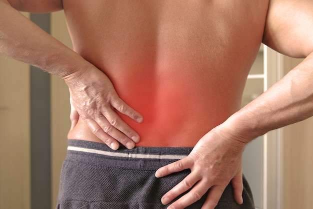 Photo lumbago symptom young man holding his painful inflamed loin health care and medicine