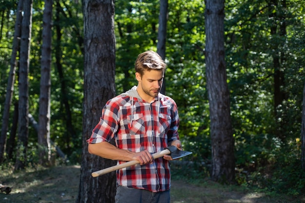 Lumberjack standing with axe on forest background deforestation is a major cause of land degradation