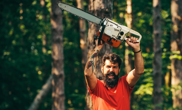 Lumberjack worker with chainsaw in the forest chainsaw lumberjack worker standing in the forest with