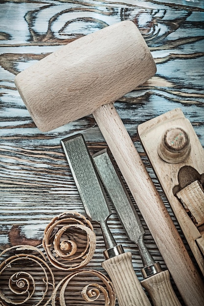 Lump hammer chisels planer planning chips on wooden board.