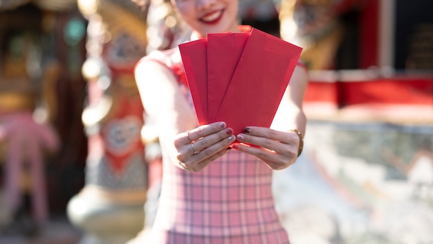 Lunar New Year celebrations with red envelopes in hands.