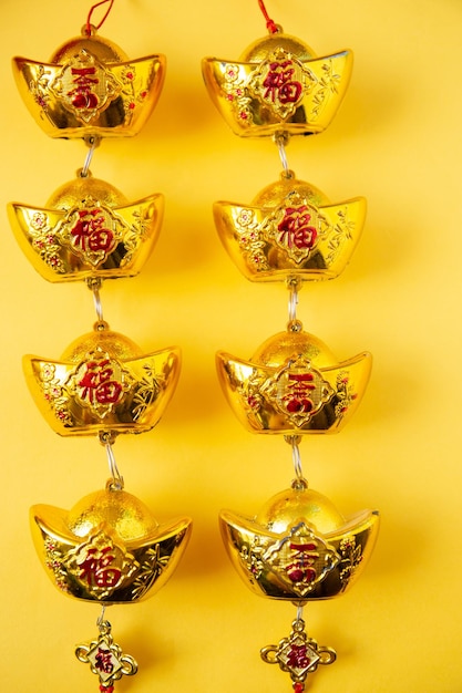 Photo lunar new year decoration with lucky gold bar isolated on yellow . tet holiday.