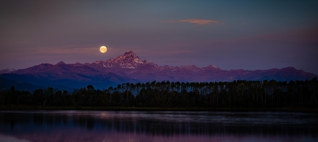 Foto il tramonto lunare dietro la montagna in italia