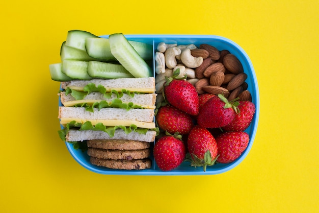 Lunch in the blue box in the center of  the yellow surface. Top view.