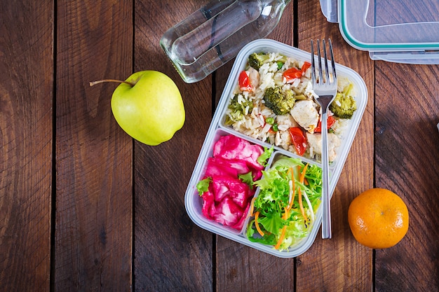 Lunch box  chicken, broccoli, green peas, tomato  with rice and red cabbage. Healthy food. Take away. Lunchbox. Top view